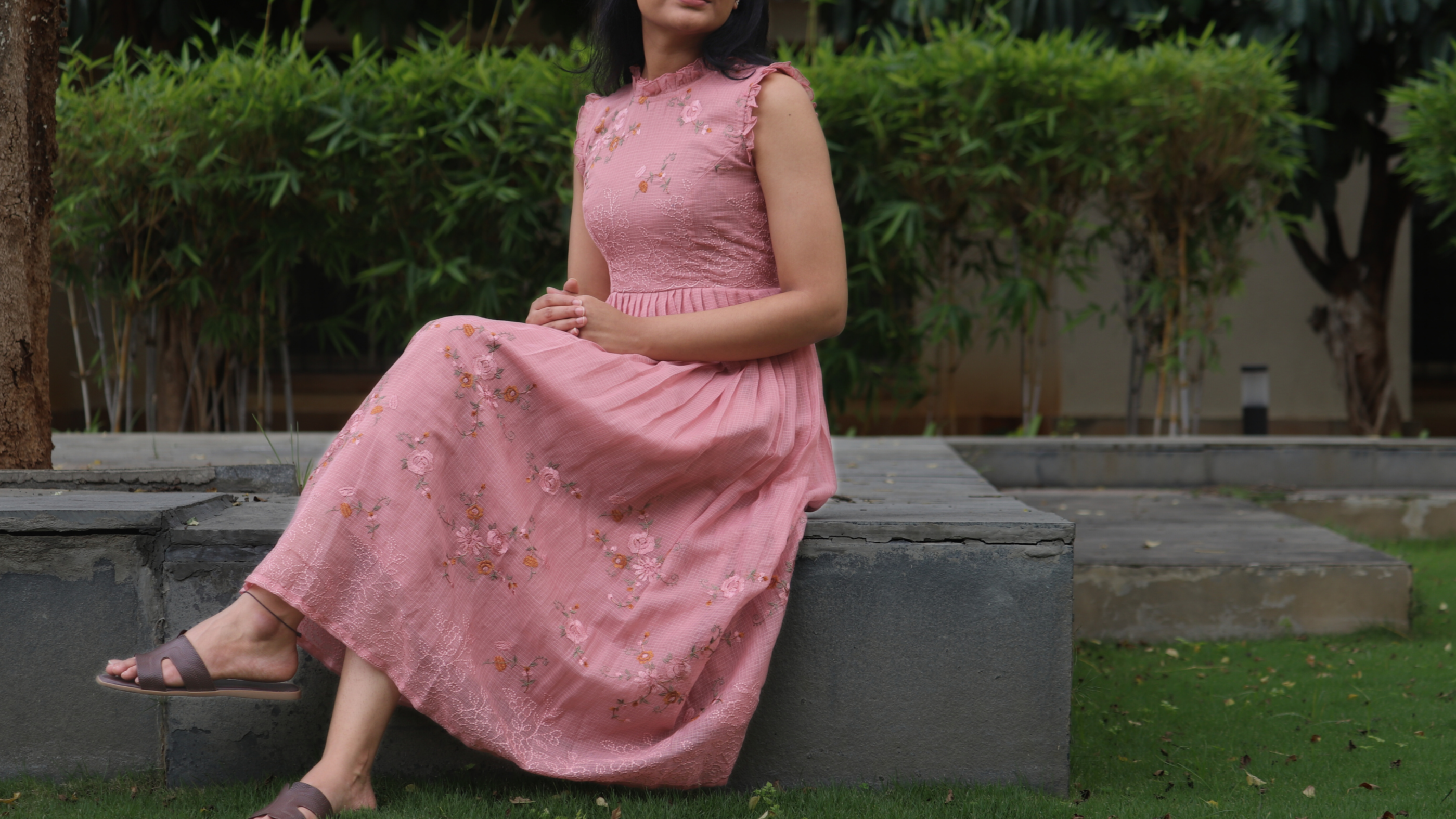 Woman in a pink dress sitting outdoors with 'Fashion Catalogue' text above