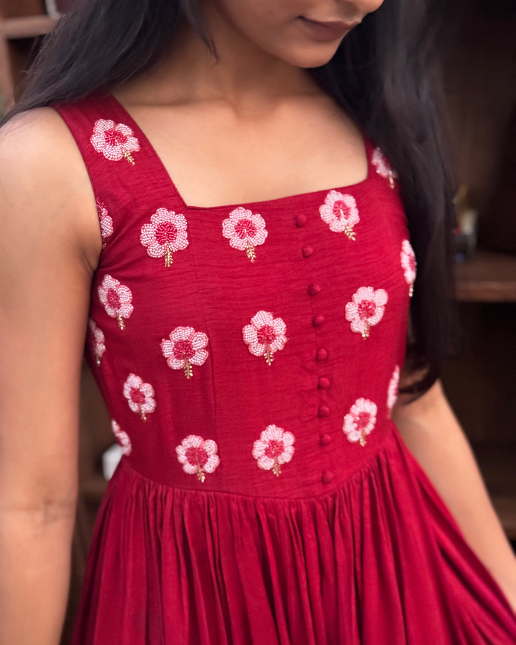 Red dress with floral patterns worn by a person