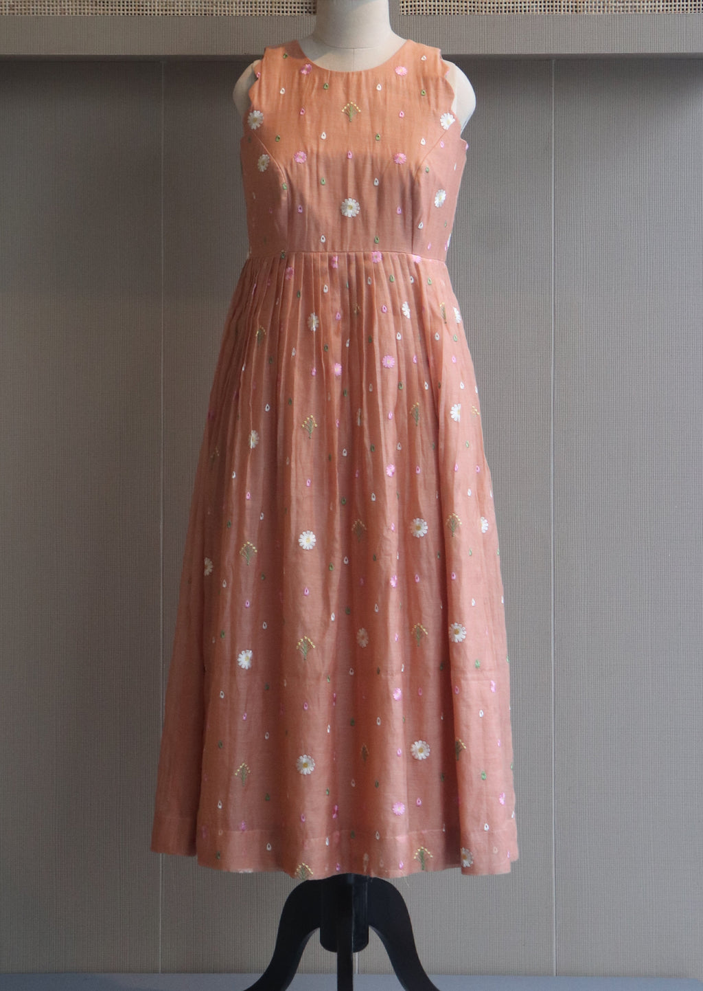 Pink evening gown on a mannequin against a neutral background