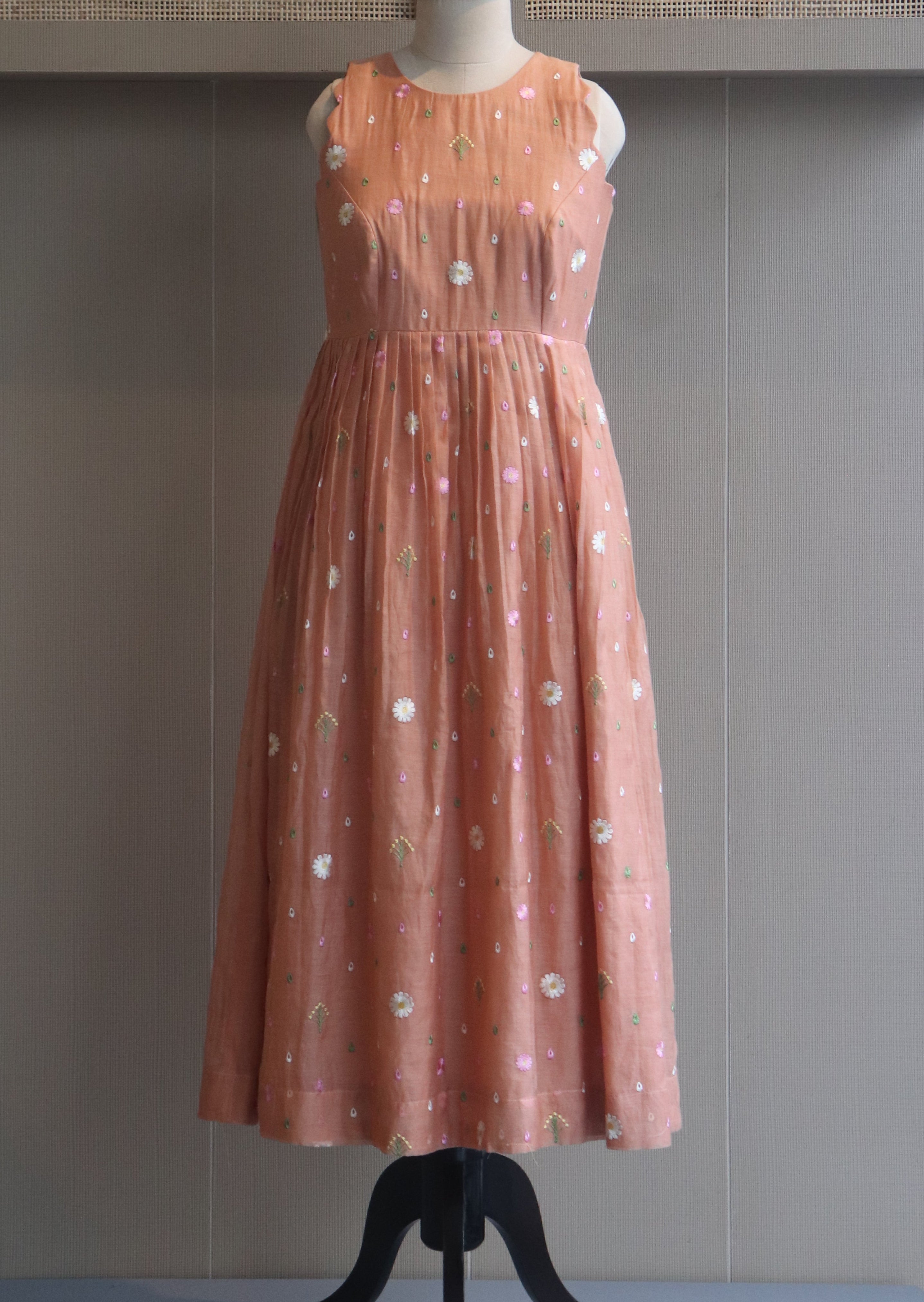 Pink evening gown on a mannequin against a neutral background