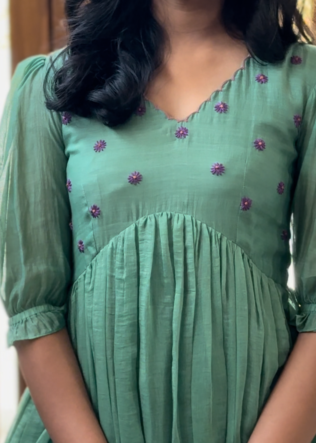Green dress with floral embroidery worn by a person