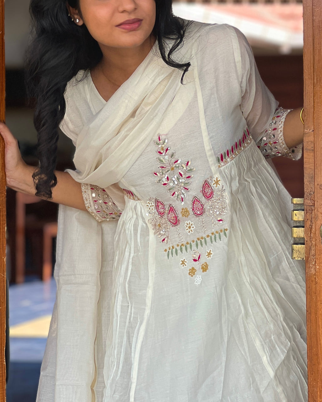 Woman wearing a white embroidered traditional outfit with a blurred background