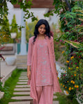 Woman in a pink traditional outfit standing in a garden